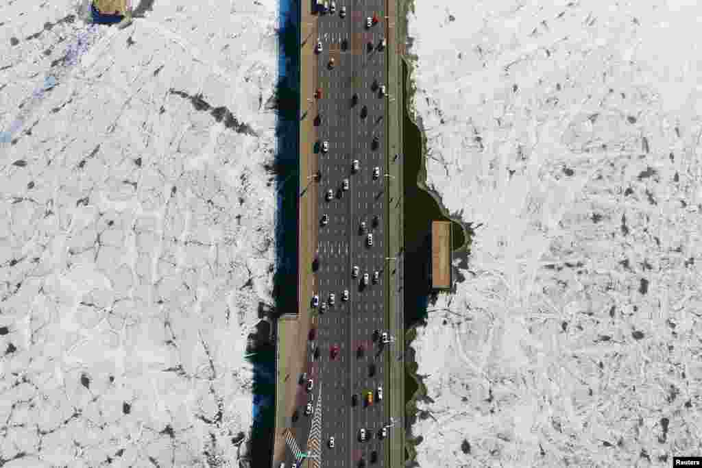 Vehicles travel on a bridge over the partially frozen Hun river in Shenyang, Liaoning province, China, Dec. 25, 2018.