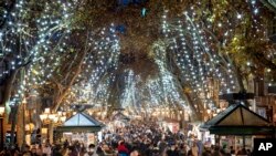People walk along La Rambla in downtown Barcelona, Spain. Spain is reporting almost 700 cases per 100,000 inhabitants over 14 days, more than double the accumulated cases before last year&#39;s Christmas holidays. The omicron strain has soared from 5% of new cases in Spain to 47% within one week.