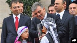 Turkey's President Abdullah Gul, center, is welcomed by children in local traditional dress, at the airport in Diyarbakir, Turkey, 30 Dec 2010