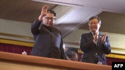 This picture captured from video footage by Korea Pool reporters shows North Korean leader Kim Jong Un (L) and South Korea's Culture, Sports and Tourism Minister Do Jong-whan (R) during a rare concert by South Korean musicians at the 1,500-seat East Pyongyang Grand Theater in Pyongyang, North Korea, April 1, 2018.