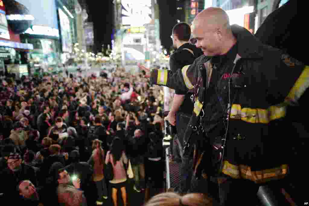 A firefighter waves to the crowd as people celebrate after al-Qaida leader Osama bin Laden was killed in Pakistan, during a spontaneous celebration in New York's Times Square, May 2, 2011. Bin Laden was killed on Sunday in a firefight with U.S. forces in 