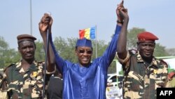 Le président Idriss Deby, au centre, lève les mains des militaires tchadiens revenus du Niger, à N’Djamena, Tchad, 11 décembre 2015.