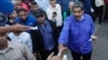 ARCHIVO - Ciudadanos entregan al presidente Nicolás Maduro papeles con peticiones durante un acto con representantes de las iglesias evangélicas de Venezuela, en Caracas, el 15 de mayo de 2024.