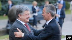 Ukrainian President, Petro Poroshenko, left, and NATO Secretary General Jens Stoltenberg, shake hands during a meeting in Kiev, Ukraine, July 10, 2017. 