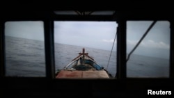 Nelayan Rusli Suhardi mengarahkan kapalnya ke wilayah pencairan ikan di pantai Natuna Besar, 9 Juli 2014. (Foto: Reuters)