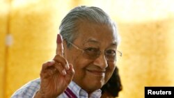 Mahathir Mohamad, former Malaysian prime minister and opposition candidate for Pakatan Harapan (Alliance of Hope), holds up an ink-stained finger as he votes during the general election in Alor Setar, Malaysia, May 9, 2018. 