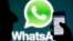 FILE - A WhatsApp logo is seen behind a smartphone, Feb. 20, 2014. Authorities in Afghanistan are temporarily blocking WhatsApp and Telegram social media services in the country.