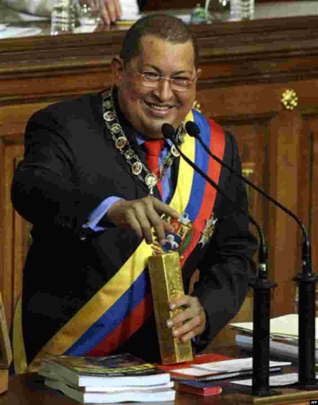 Venezuela's President Hugo Chavez speaks holding a gold bar as he gives his annual address to the National Assembly in Caracas, Venezuela, Friday Jan. 13, 2012. Chavez defended government policies, including his recent decision to withdraw billions of do
