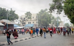 Somalis protest against the killing Friday night of two people during an overnight curfew, intended to curb the spread of the new coronavirus, on a street in Mogadishu, Somalia, April 25, 2020.