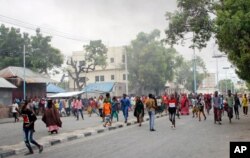 Somalis protest against the killing Friday night of two people during an overnight curfew, intended to curb the spread of the new coronavirus, on a street in Mogadishu, Somalia, April 25, 2020.