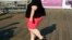 FILE - A woman walks along a boardwalk in New York.