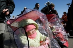 An adopted Chinese child sleeps in a stroller at Tiananmen Square in Beijing, March 7, 2007.