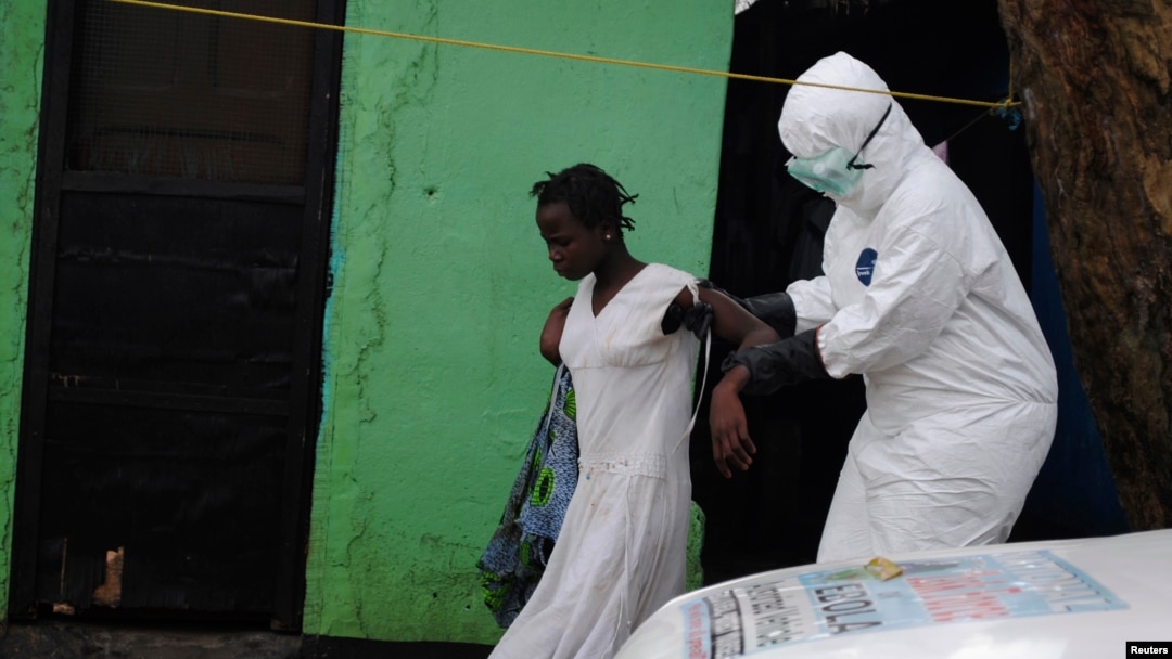 Petugas kesehatan membawa pasien perempuan yang diduga terjangkit virus Ebola ke dalam ambulans di Monrovia, Liberia (15/9). (Reuters/James Giahyue)