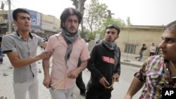 Protesters hold slingshots during clashes with riot policemen in Sulaimaniya, 260 km (162 miles) northeast of Baghdad, April 18, 2011