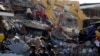 Rescue workers recover a body from the rubble as a bulldozer removes the debris of a collapsed building felled by a 7.8-magnitude earthquake, in Manta, Ecuador, April 19, 2016. 