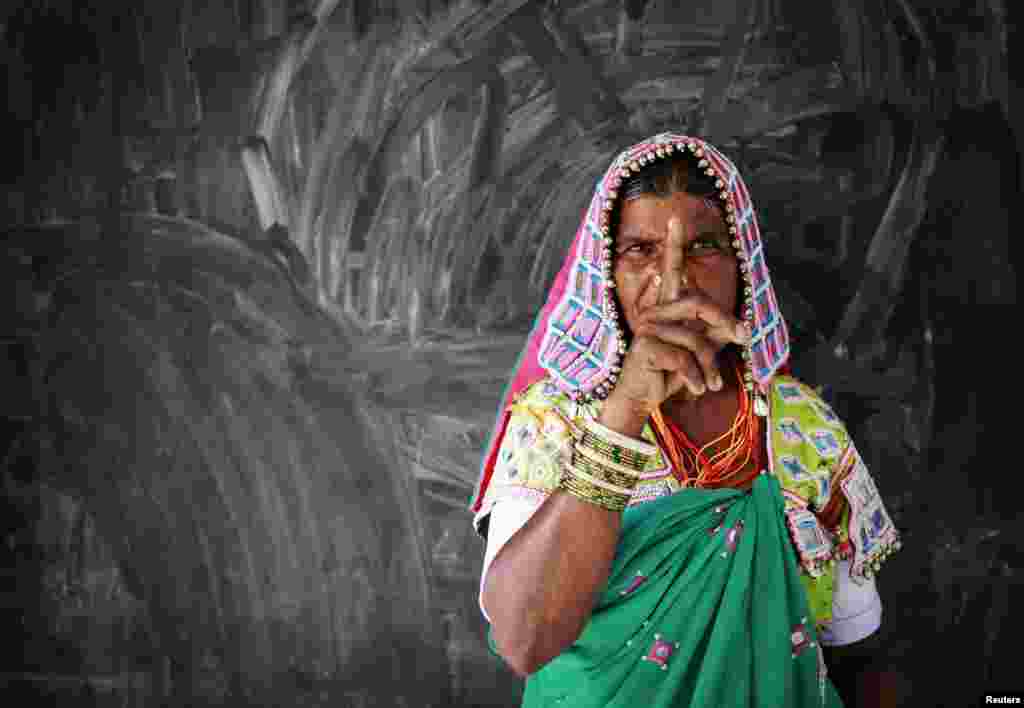 A tribal woman shows her ink-marked finger after voting at a polling center in Rangareddy district in Andhra Pradesh, India, April 30, 2014. 