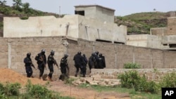 FILE - Malian Police officers take position outside Campement Kangaba, a tourist resort near Bamako, Mali, June. 19, 2017.