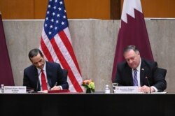 Secretary of State Mike Pompeo, right, and Qatar's Deputy Prime Minister Mohammed bin Abdulrahman Al Thani sign a memorandum of understanding during the U.S.-Qatar Strategic Dialogue at the State Department, Sept. 14, 2020, in Washington.