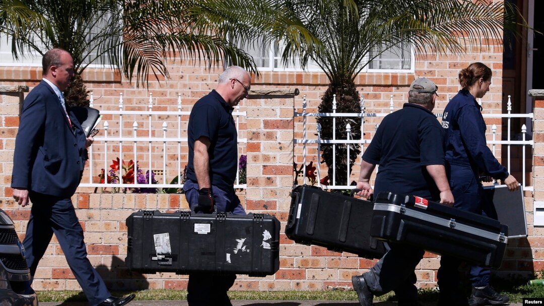 Petugas forensik kepolisian Australia membawa peralatan ke dalam rumah yang digerebek di Sydney, terkait dugaan terorisme (18/9). (Reuters/David Gray)