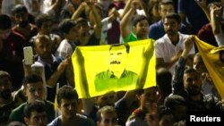 Supporters hold a flag with the image of Abdullah Ocalan, jailed leader of the Kurdistan Workers' Party (PKK) as they celebrate outside the pro-Kurdish Peoples' Democratic Party (HDP) headquarters in Diyarbakir, Turkey, June 7, 2015. 
