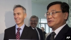 AP President Tom Curley, left, and Korean Central News Agency President Kim Pyong Ho hold an Associated Press Pyongyang sign before hanging it on the door of the new AP bureau in Pyongyang, Jan. 16, 2012.