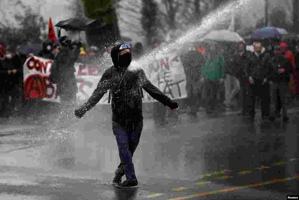 A demonstrator faces off with French gendarmes during a demonstration by labor union members and workers on strike in Nantes during the 36th consecutive day of strikes against the government&#39;s pensions reform plans.