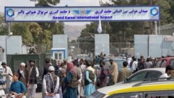 FILE - People gather at the entrance gate of Hamid Karzai International Airport a day after U.S troops withdrawal, in Kabul, Afghanistan, August 31, 2021.