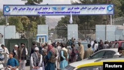 FILE - People gather at the entrance gate of Hamid Karzai International Airport a day after U.S troops withdrawal, in Kabul, Afghanistan, August 31, 2021. 