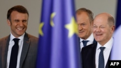 French President Emmanuel Macron, Polish Prime Minister Donald Tusk and German Chancellor Olaf Scholz arrive for a press conference at the Chancellery in Berlin on March 15, 2024. The three announced plans to use profits from frozen Russian assets to buy arms for Ukraine.