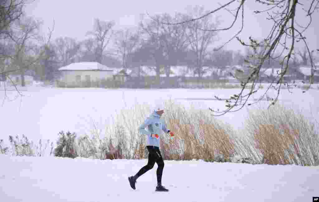 Una corredora recorre Washington Park mientras la tormenta invernal azota las montañas del oeste en Denver.