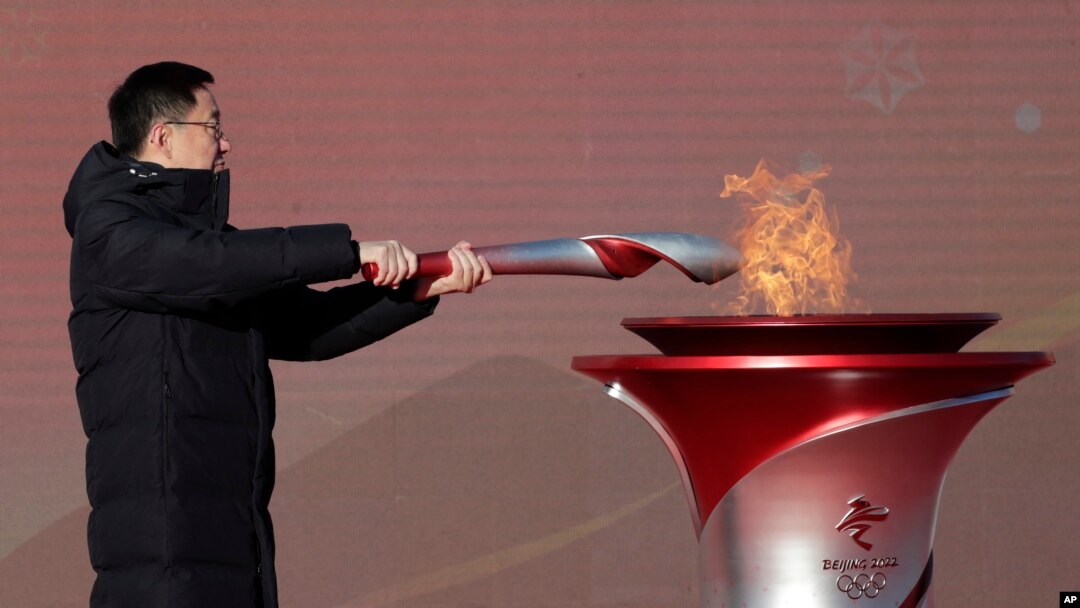 El viceprimer ministro de China, Han Zheng, enciende la antorcha olímpica antes del inicio del relevo para los Juegos Olímpicos de Invierno de Beijing 2022, en el parque olímpico de Beijing, el 2 de febrero de 2022.