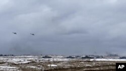 En esta foto tomada de un video y publicada por el Servicio de Prensa del Ministerio de Defensa de Rusia el miércoles 2 de febrero de 2022, tanques y helicópteros militares rusos y bielorrusos asisten a ejercicios militares conjuntos en el campo de tiro de Brestsky, Bielorrusia.