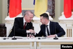 Presiden Ukraina Volodymyr Zelenskiy dan Presiden Turki Tayyip Erdogan berjabat tangan dalam konferensi pers bersama seusai pertemuan mereka di Istana Mariyinsky di Kyiv, Ukraina 3 Februari 2020. (REUTERS/Gleb Garanich)