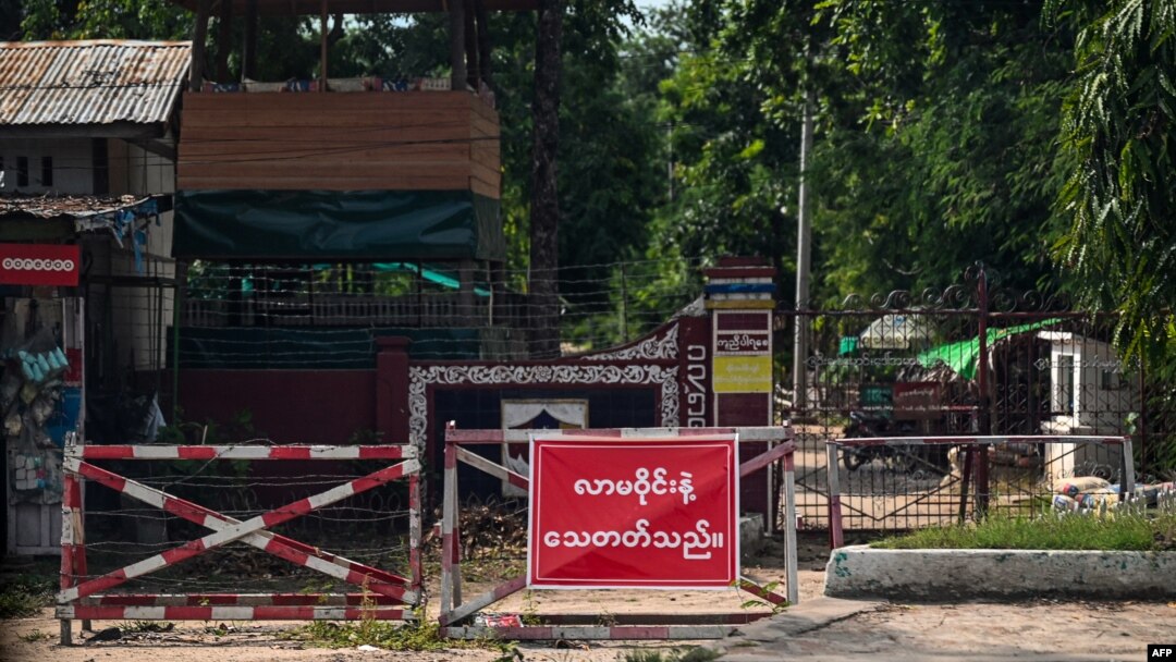 FILE - This Oct. 10, 2021, photo shows a sign that reads, 'Do not come around! You can get killed' at the gate of a police station in Shwebo township in Myanmar's Sagaing region.