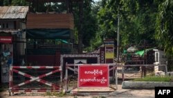 FILE - This Oct. 10, 2021, photo shows a sign that reads, 'Do not come around! You can get killed' at the gate of a police station in Shwebo township in Myanmar's Sagaing region.