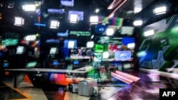 Seorang pembawa acara televisi Russia Today (RT) bersiap mengudara di studio mereka di Moskow, Rusia, 8 Juni 2018. (Yuri KADOBNOV / AFP)