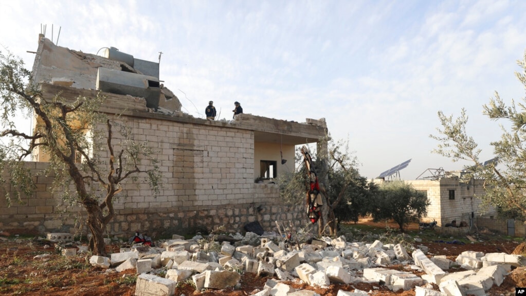 在叙利亚伊德利卜省的阿特梅赫镇，在美军展开一次突击行动后，人们查看被毁坏的一座房屋。(2022年2月3日)(photo:VOA)