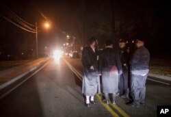 Orthodox Jews talk to a police officer near the scene of a stabbing that occurred late Saturday during a Hanukkah celebration, in Monsey, New York, Dec. 29, 2019.