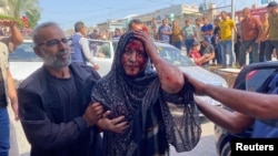 Ciudadanos asisten a una mujer que ha resultado herida durante un ataque aéreo israelí en la Franja de Gaza, el 24 de octubre de 2023.