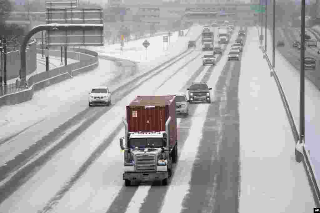 Pocos automovilistas se dirigen hacia el sur a lo largo de la Interestatal 25 en el paso elevado de Steele Street, mientras la tormenta invernal se extiende sobre las montañas del oeste en Denver.