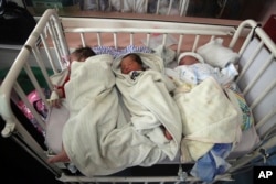 Bayi-bayi yang baru lahir berbaring di tempat tidur mereka di Rumah Sakit Anak Ataturk, sehari setelah diselamatkan dari rumah sakit bersalin lain, menyusul serangan mematikan di Kabul, Afghanistan, Rabu, 13 Mei 2020. (AP Photo/Rahmat Gul)