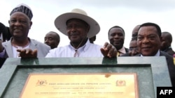 FILE - Uganda's President Yoweri Museveni poses with King of Bunyoro, Solomon Iguru the first (L) and Minister of foreign Affairs of Tanzania Dr. Augustine Mahiga (R) marking the start of the first East Africa Crude Oil Pipeline (EACOP) in Kabaale. Taken November 11, 2017. 