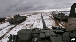 In this photo taken from video released by the Russian Defense Ministry Press Service on Feb. 2, 2022, Russian and Belarusian tanks drive during joint military drills at Brestsky firing range, Belarus.