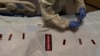 Registered nurse Bryan Hofilena attaches "COVID Patient" stickers on a body bag of a patient who died of coronavirus at Providence Holy Cross Medical Center in Los Angeles, Dec. 14, 2021.