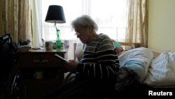 La refugiada ucraniana Tamila Melnichenko, de 82 años, de Kiev, lee un libro en su habitación en la casa de retiro Armada en Glogoczow, Polonia, el 10 de febrero de 2023.