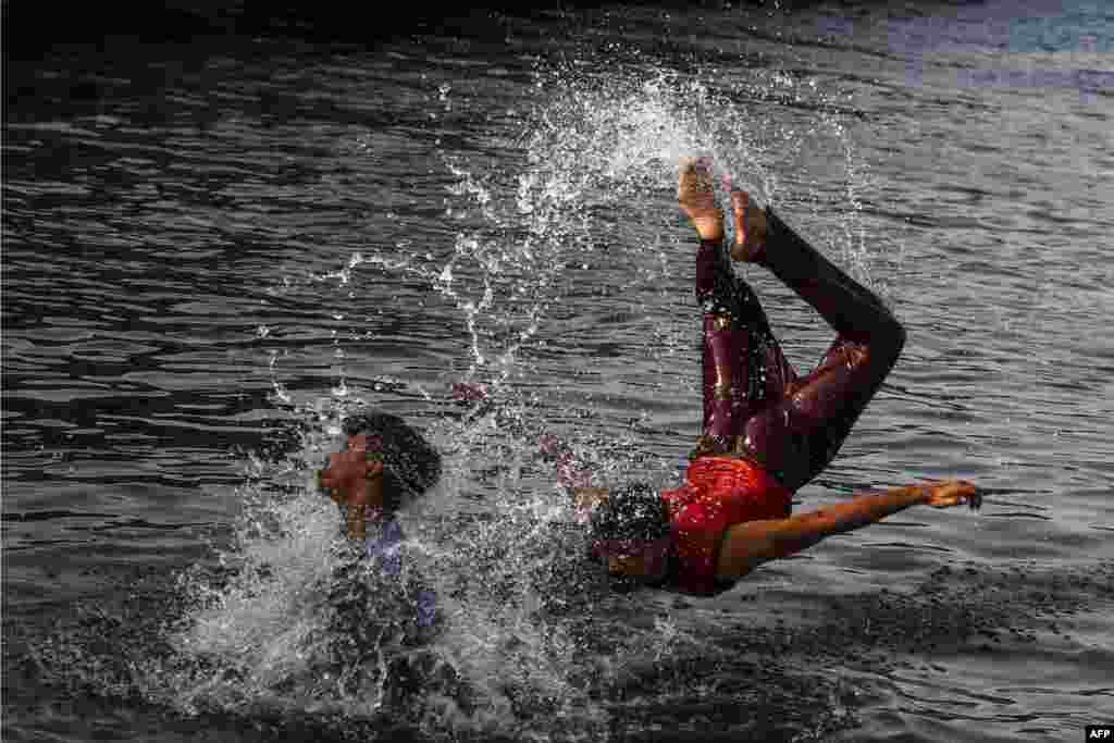 Men cool off into Arabian Sea water during a hot summer day in Karachi, Pakistan.