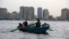 An Egyptian woman rows a boat with her family along the Nile River, in Cairo, Egypt, May 31, 2013.