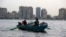 An Egyptian woman rows a boat with her family along the Nile River, in Cairo, Egypt, May 31, 2013.