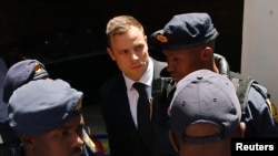 Pelari Olimipiade dan Paralimpik Afrika Selatan Oscar Pistorius (tengah) dikawal ke mobil polisi menyusul vonis hukuman di Pengadilan Tinggi North Gauteng di Pretoria, 2014.