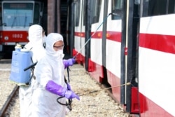 Members from an emergency anti-epidemic headquarters in Mangyongdae District, disinfect a tramcar of Songsan Tram Station to prevent new coronavirus infection in Pyongyang, North Korea, Feb. 26, 2020.